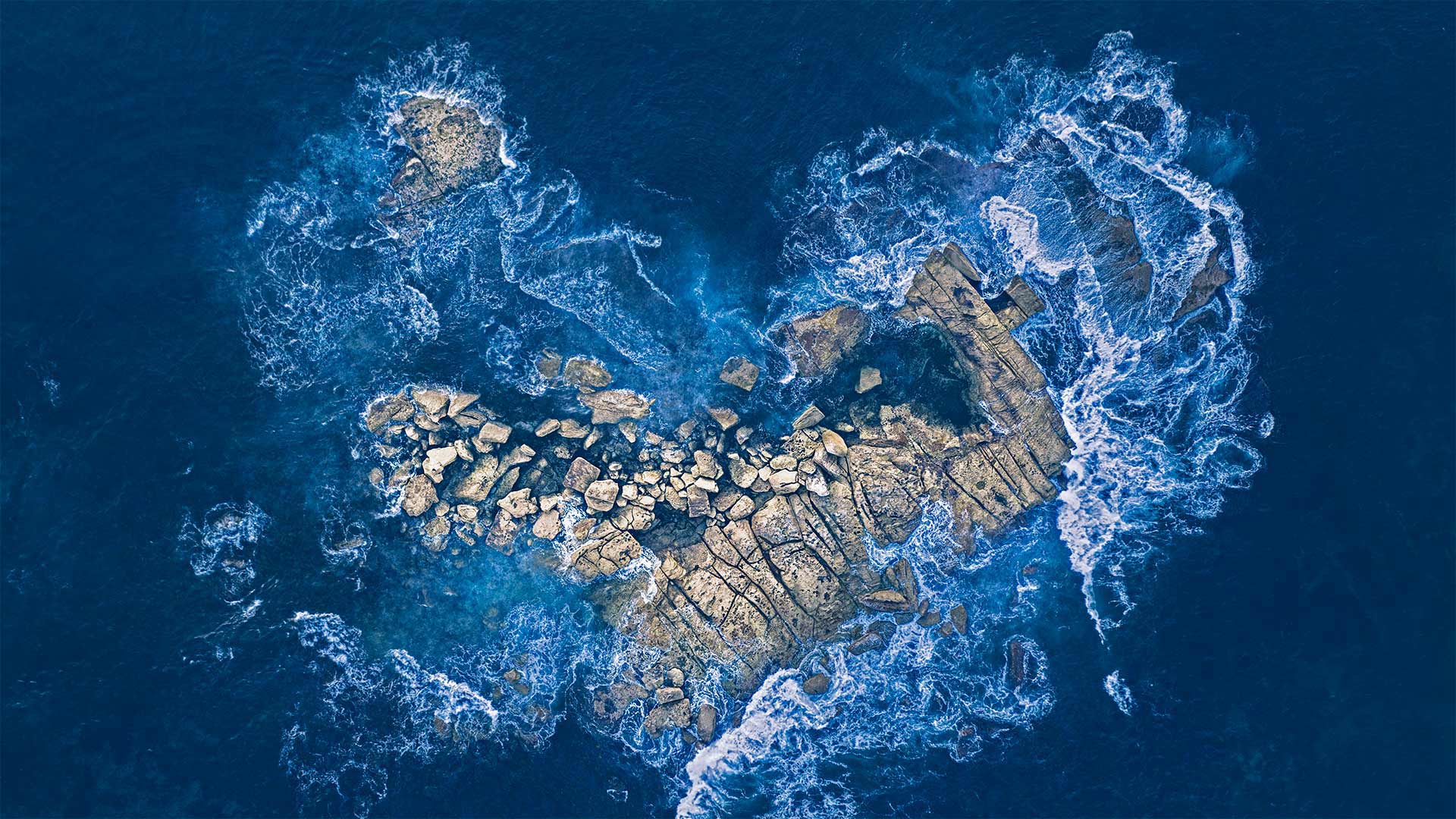 海浪冲击着悉尼海岸的一个心形岩石岛，澳大利亚 (© Kristian Bell/Getty Images)
